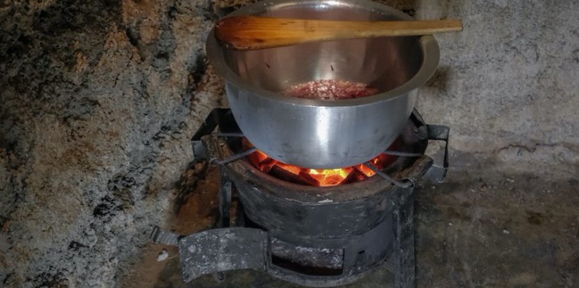 A pot sits on charcoal embers