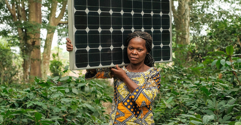 Woman carries a solar panel