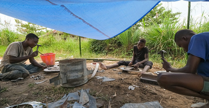 Men work on stove construction under under a tarpaulin