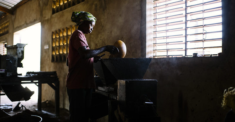 A woman works on shea butter processing